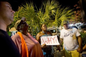 People gather to mourn while holding hands in Charleston, SC.